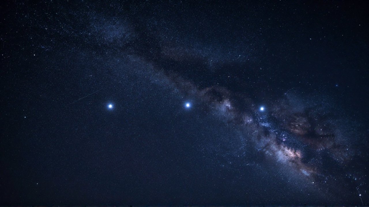 Tres estrellas brillantes alineadas que forman el cinturón de Orión bajo un cielo nocturno profundo.