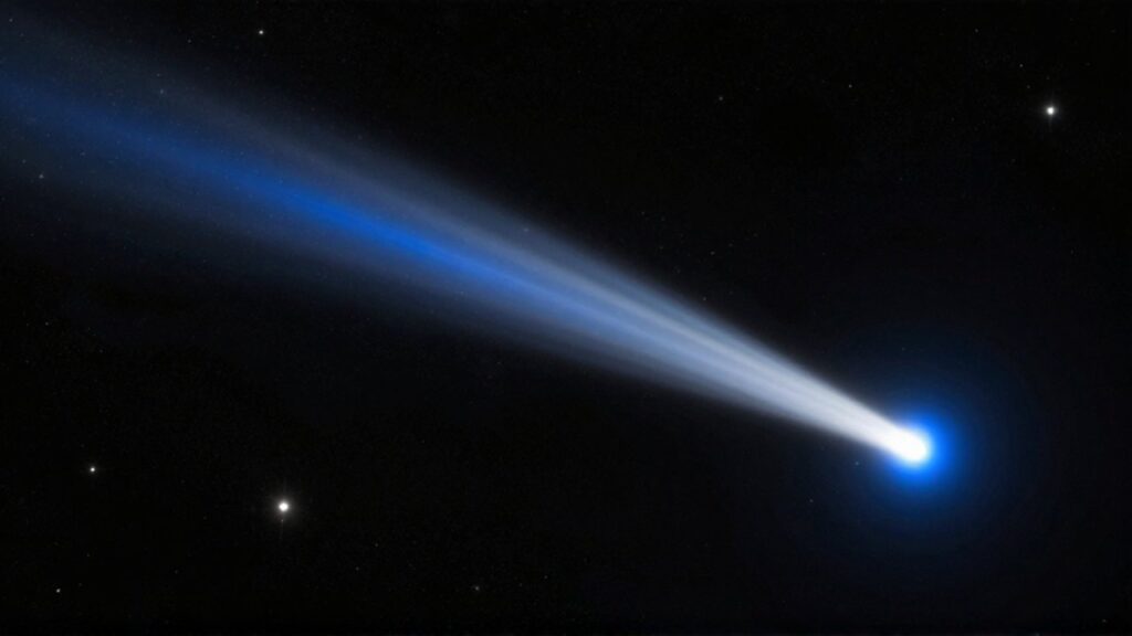 Cometa brillante con colas azul y blanca atravesando el espacio profundo entre estrellas y nebulosas.