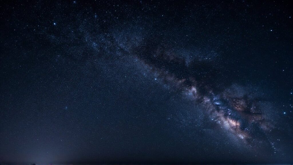 Cielo nocturno ecuatorial con constelaciones brillantes y densos cúmulos de estrellas sobre un fondo azul profundo.