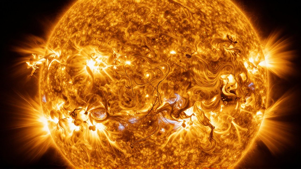 Primer plano detallado de la superficie solar con plasma dorado en movimiento y llamaradas eruptivas.